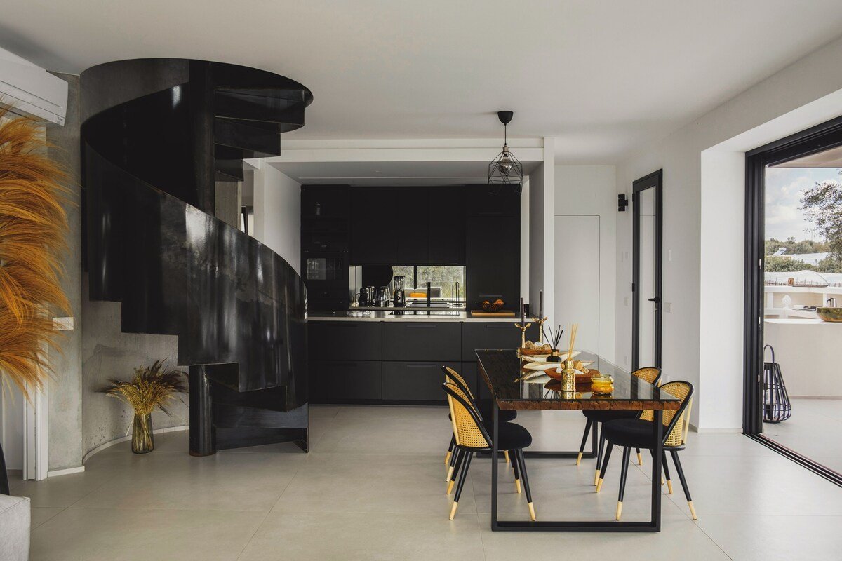 Cuisine intérieure noire avec escalier colimaçon